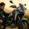 朝焼けの山岳ロードで日本人ライダーがアフリカツイン1100に荷物を積み、ツーリングの準備をする情景（16:9）— 自由と冒険を感じさせる中古バイク購入ガイド用アイキャッチ画像