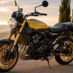 夕暮れの黄金色の光の中、上品な屋外の舗装路に停車したカワサキZ900RS風のバイクを、左向きのフロント斜めから写したリアルなヒーロー画像。丸型ヘッドライト、しずく型タンク、黒と黄色のクラシックなカラーリング、金色のホイール、直列4気筒エンジン、磨かれた金属パーツが強調され、背景には柔らかくぼけた山並みと樹木が見える。