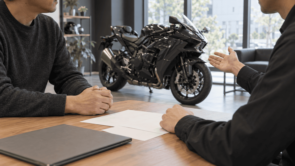 Ninja H2の買取相場はいくら?高騰理由と高く売る判断基準 店内のバイクを前に書類を確認しながら査定条件を相談する成人2人